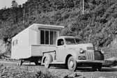 Photo shows a vintage chevy pickup truck towing a 1941 manufactured trailer