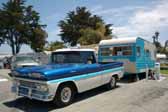Photo shows a 1961 chevy apache pickup truck vintage tow vehicle pulling a 1958 roadliner travel vintage trailer