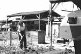 Vintage photo of a woman hoeing her garden near the camp trailers in the 1940's, at the Hanford Trailer Camp in Washington