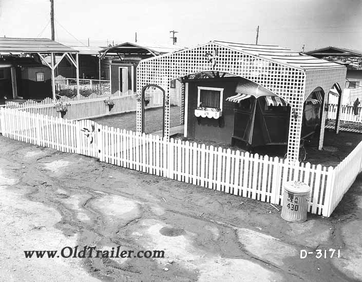 Government photo shows a 1940's vintage travel trailer under a white lattice sun cover at the Hanford Trailer City