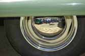 Great example of buttercup yellow wheels with a chrome hubcap and chrome beauty rings mounted on a vintage trailer painted green