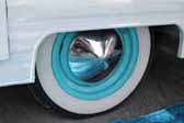 Picture shows an example of vintage trailer wheels painted sky blue and with a pointy chrome hubcap