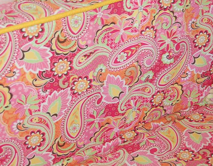 This photo shows a swatch of retro fabric with a 1960's psychedelic paisley pattern, for your vintage trailer