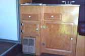 Picture of beautiful birch wood kitchen cabinets with heater and stovetop in interior of super rare 1941 Western Flyer motor home