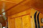 Photo of warm and glowing cabinetry and paneling in vintage 1948 Westwood Coronado trailer