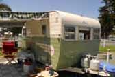 Beautifully restored 1955 Aljoa Sportsman Travel Trailer painted green and creme