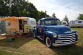 Classic 1958 Aloha trailer next to vintage chevy pickup truck tow vehicle