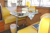 Sunny yellow dinette seats in dining area in 1959 Shasta Airflyte Trailer
