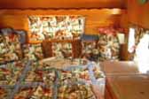1962 Shasta Trailer with honey gold paneling and colorful retro cowboy-theme comforter
