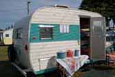 Bright 1965 vintage Aloha travel trailer painted in attractive turquoise and blue color design