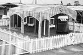Historical photo of a 1940's worker's trailer, surrounded by a beautiful white picket fence, at Project Hanford Trailer City