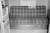 Old photo shows the plaid couch in a 1940's Government Model Trailer, at the Hanford Trailer Camp