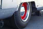 Example of beautiful red wheels with a small chrome baby moon hubcap mounted on a rare airstream vintage trailer