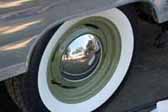 Nice example of olive green wheels with a small baby moon hubcap, on a vintage trailer