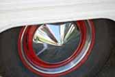 Photo shows red painted vintage trailer wheels with pointy hubcap and beauty rings