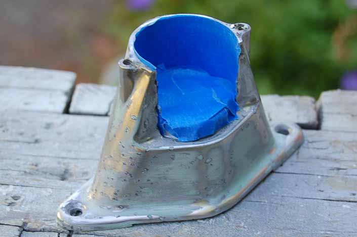 In this photo we are using blue masking tape to protect the bulb socket in the vintage trailer license plate lamp housing, before painting it