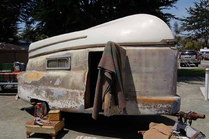 Original fiberglass boat attached to the roof of a rare vintage 1954 Kompak trailer