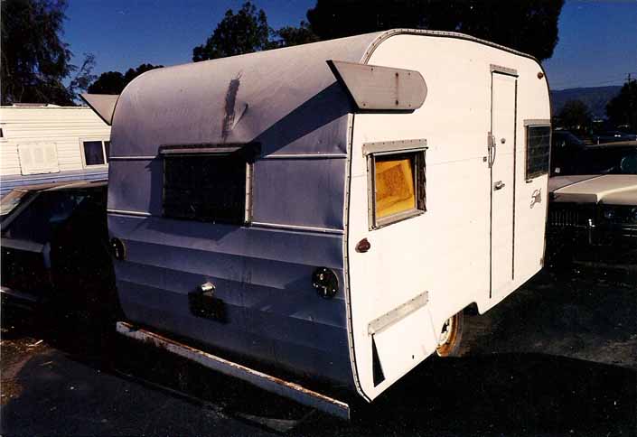 Tired but restorable 1962 Shasta 1500 trailer in a vintage trailer junk yard, in original condition