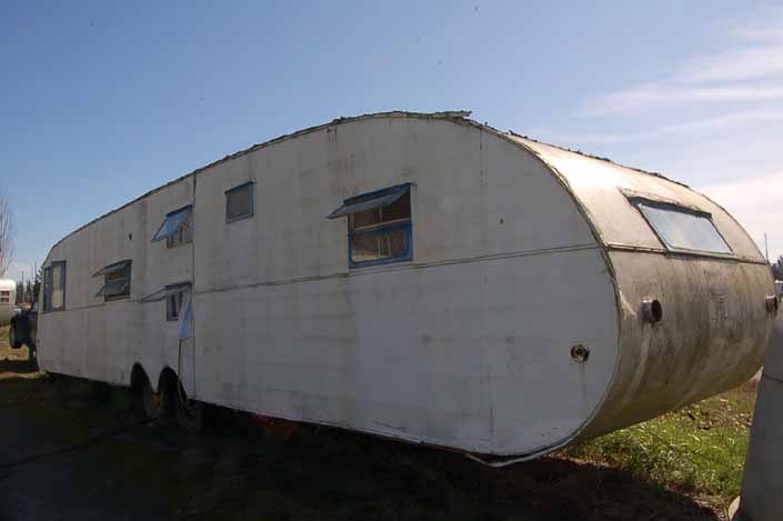 Vintage trailer junk yard has a long vintage Traveleze trailer ready for restoration