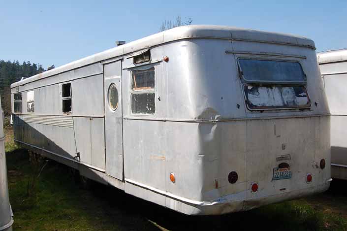 Vintage trailer junk yard has a long Spartan Manor trailer awaiting restoration