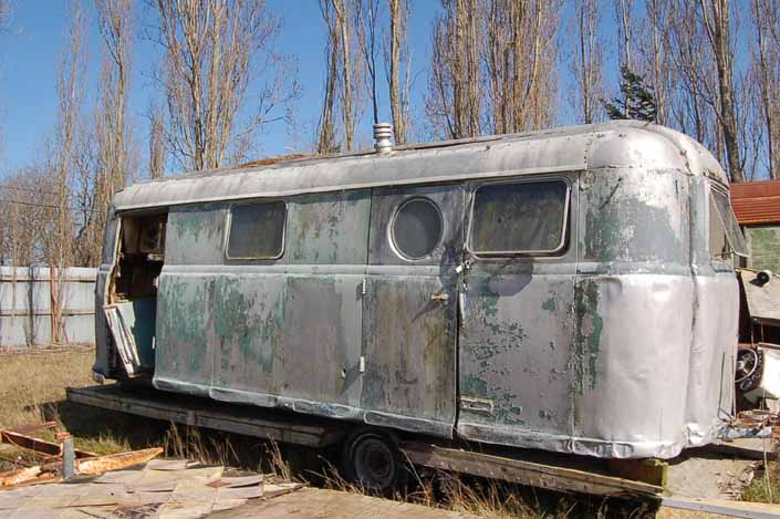 Vintage trailer junk yard has a mostly complete Palace vintage trailer ready to be restored