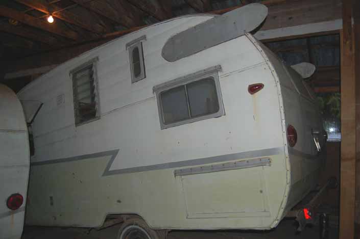 Vintage trailer junkyard has a Shasta Airflyte trailer with home-made wings and a flipped axle, available for restoration